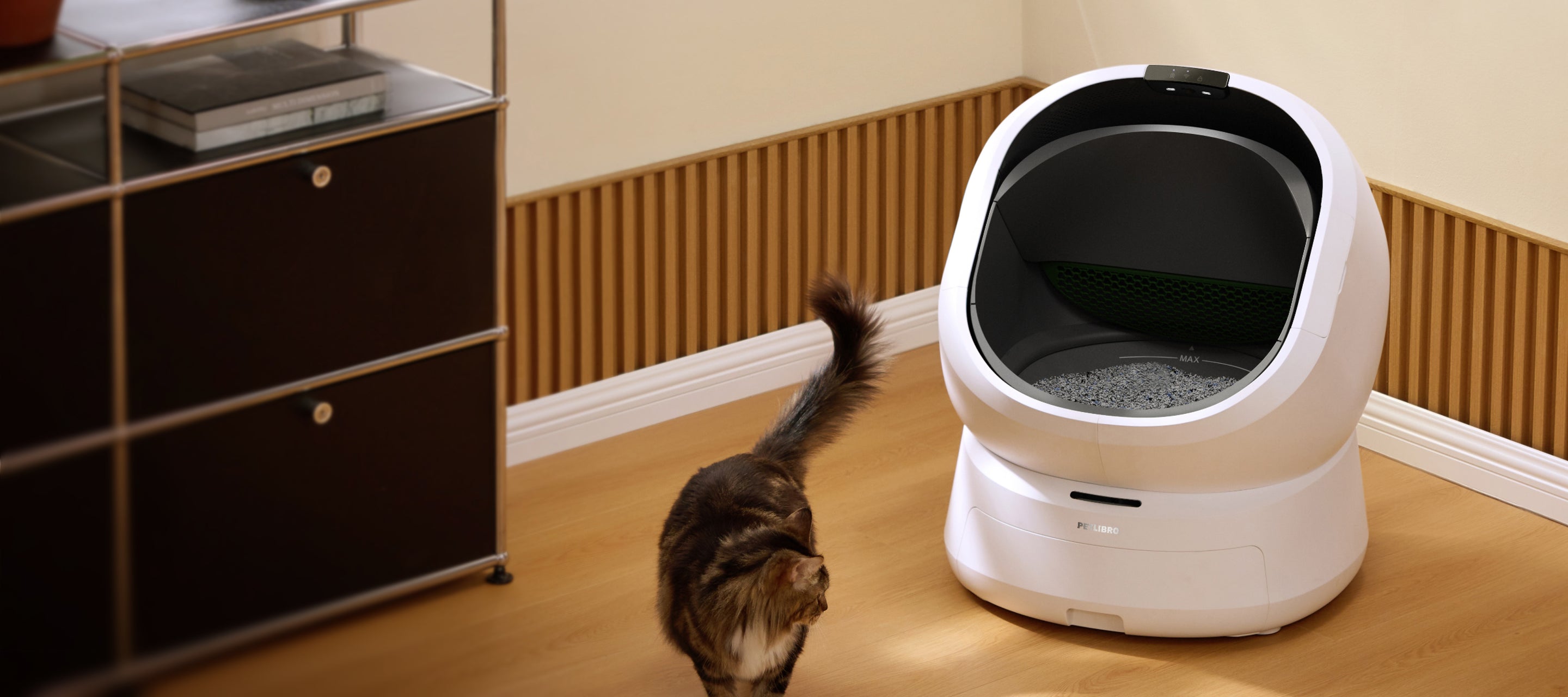 Petlibro automatic self-cleaning cat litter box in white with black interior, shown in a home setting with a cat nearby