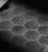 Petlibro close-up of a black textured pet grooming mat covered with light-colored pet hair fibers