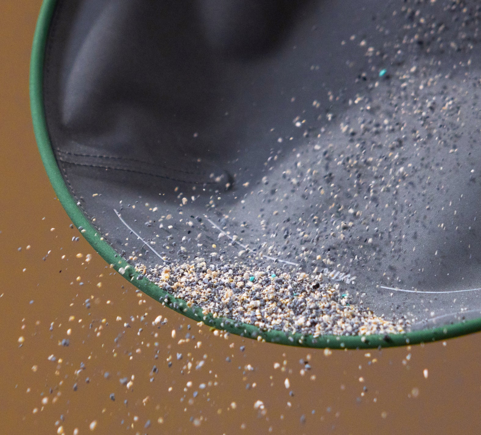 Petlibro black and green pet litter mat catching and containing scattered litter granules in motion