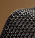 Petlibro close-up of black hexagonal textured surface with fabric edge, likely part of a pet accessory or mat