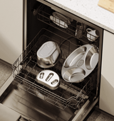Petlibro stainless steel pet feeding bowls in dishwasher on kitchen floor with white countertop and cabinets